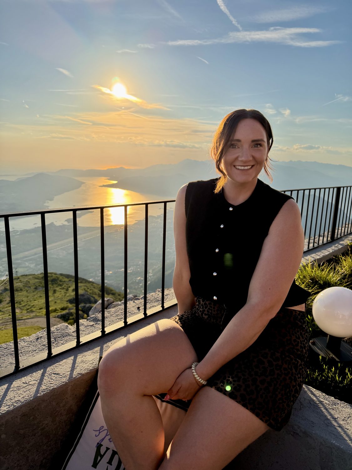 Elizabeth Scott smiling, seated on a terrace at sunset